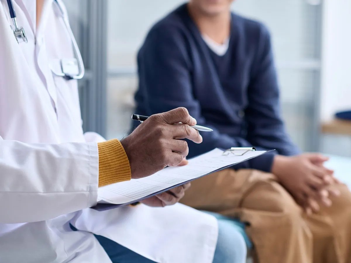 Profissional de saúde anotando informações durante consulta com paciente